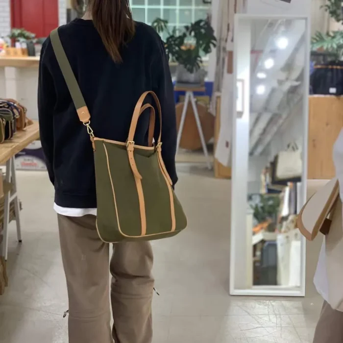 Urban lifestyle shot with Original Canvas & Leather Tote Bag – Carrying books, tablet, and daily essentials