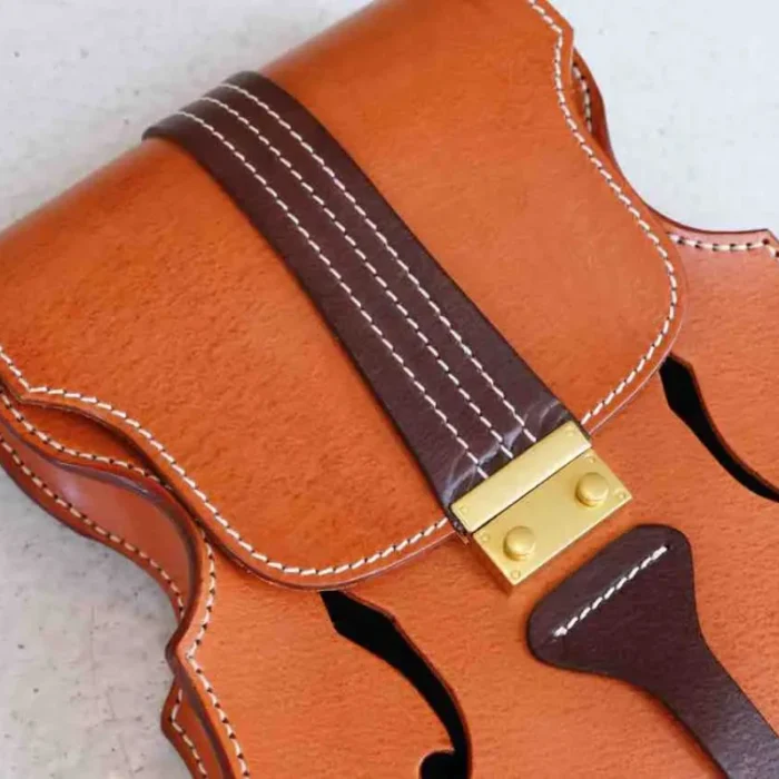 Front view of handcrafted honey-brown leather backpack inspired by violin curves