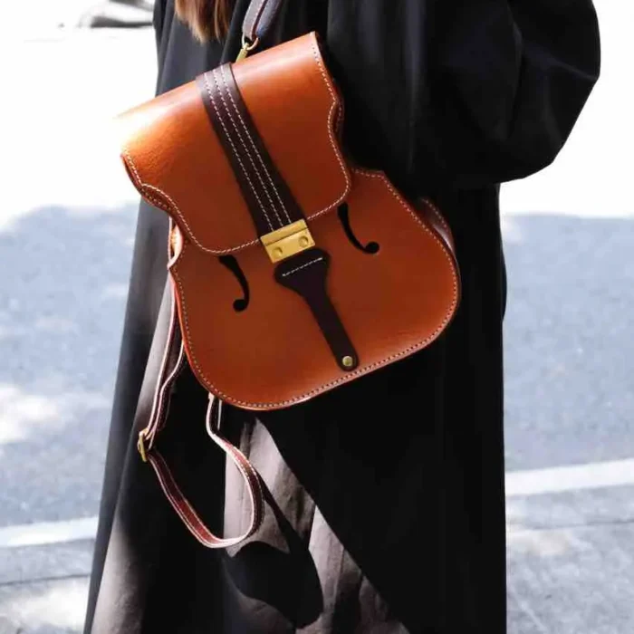 Designer and violinist wearing her own handcrafted honey-brown leather backpack, blending music and craft