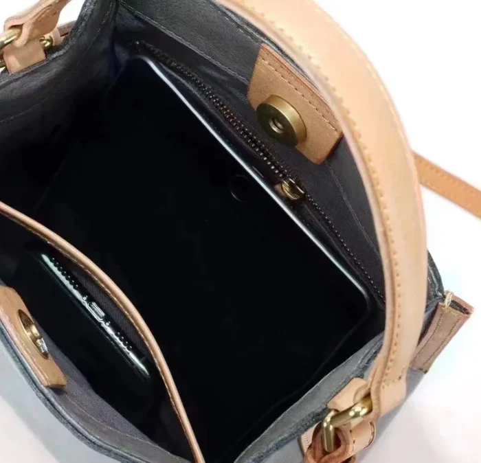 Interior compartments of handcrafted vegetable-tanned leather contrast bag with zipper pocket