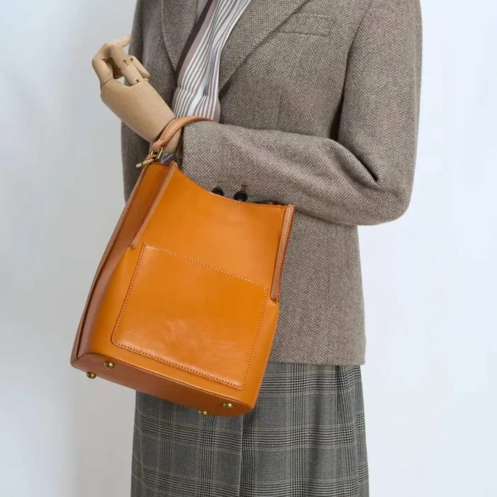 Model wearing handcrafted vegetable-tanned leather contrast bag crossbody style
