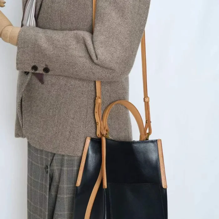 odel carrying handcrafted vegetable-tanned leather contrast bag as a shoulder bag
