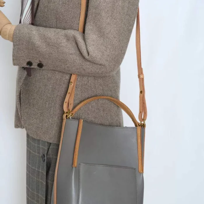 Model wearing handcrafted vegetable-tanned leather contrast bag crossbody style