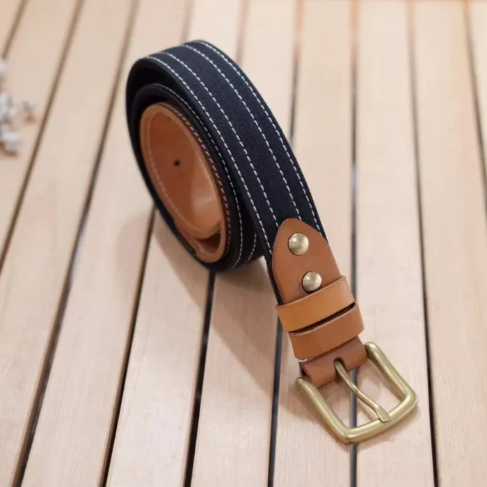 black canvas and vegetable-tanned leather belt with brass buckle and contrast stitching