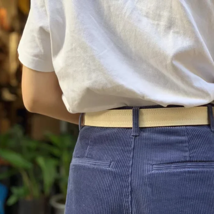 female model pairing white canvas leather belt with denim for a clean summer look