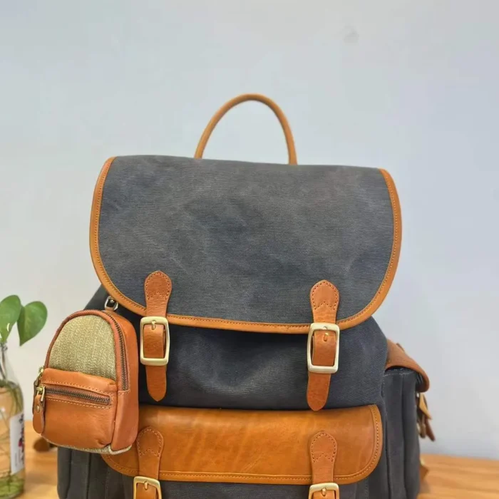Mini Backpack Charm hanging on a backpack, holding small accessories like earphones and keys