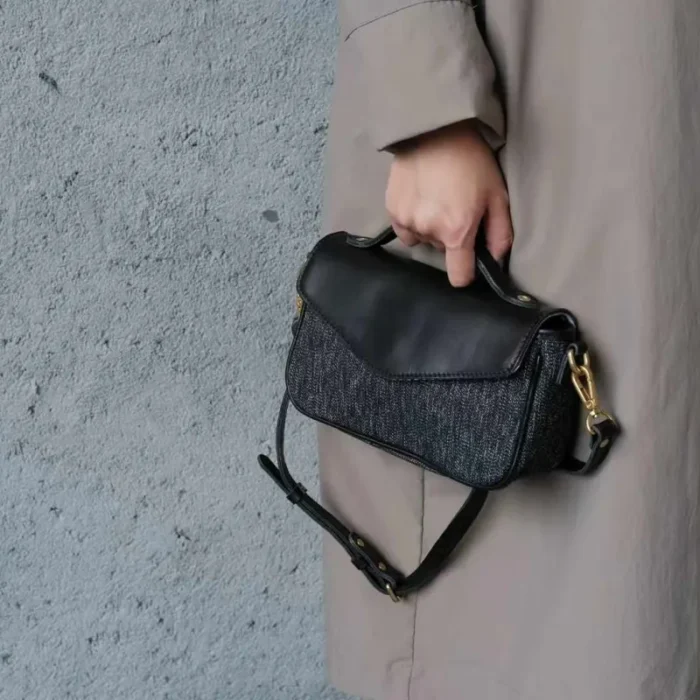 Pepper Black canvas crossbody bag detail shot, highlighting leather patina