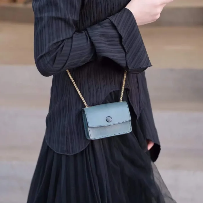 Model showcasing the Aqua Blue mini crossbody, highlighting its appeal as a niche, cool-toned accessory.