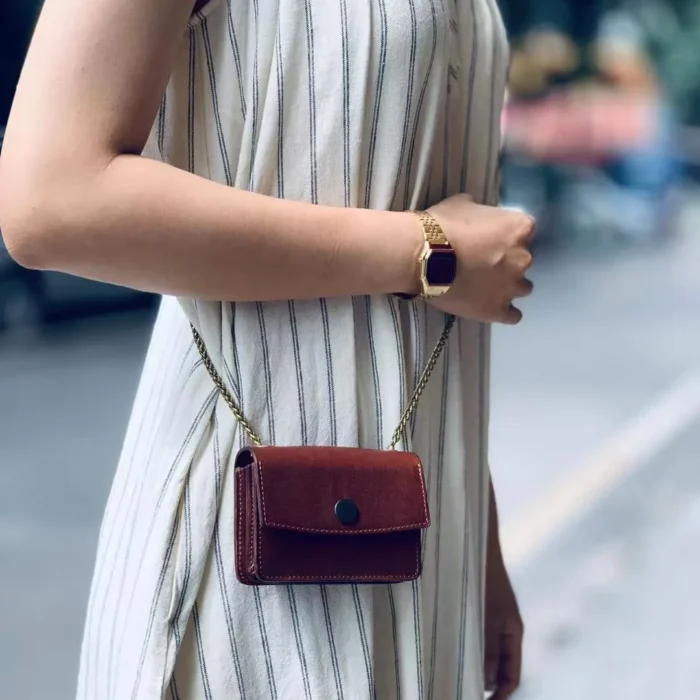 Deep Brown mini pouch worn by model, showing how the classic color adds a sophisticated touch to the outfit.