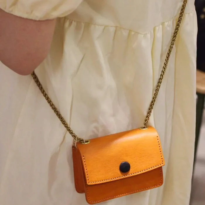 Model wearing the Sunset Yellow mini pouch crossbody, demonstrating its perfect size as a bold accessory.
