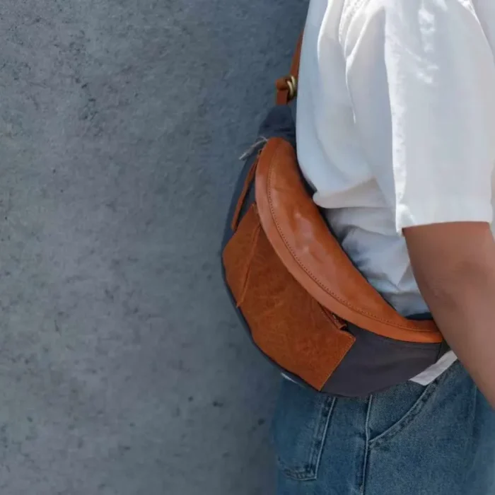 Unisex model showcasing the Canvas Leather Sling Bag in a casual urban setting.