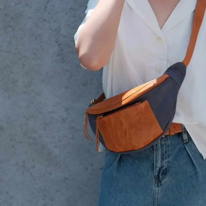 Unisex model showcasing the Canvas Leather Sling Bag in a casual urban setting.