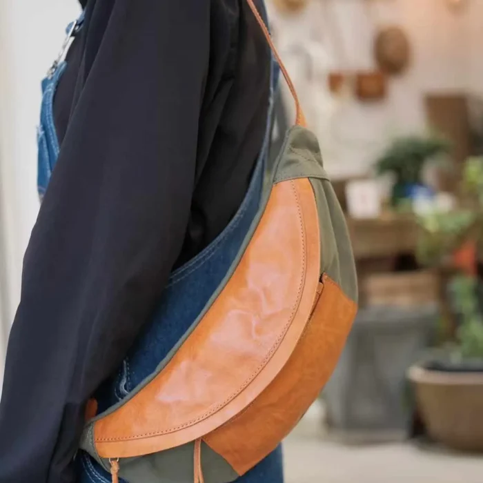 Woman wearing Deep Gray Canvas Leather Sling Bag as a trendy chest bag.