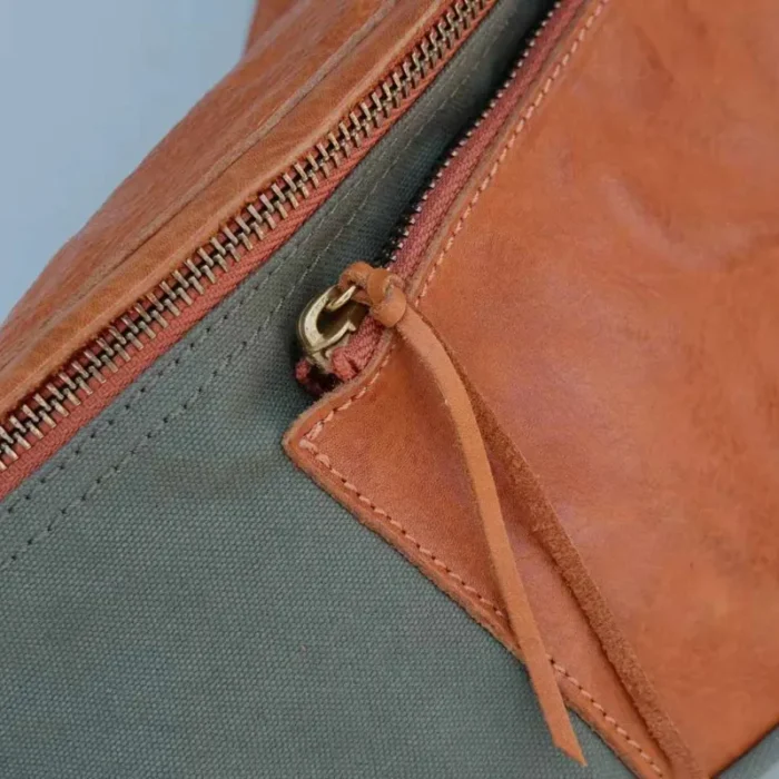 Functional and elegant zipper closure of the Canvas Leather Sling Bag.