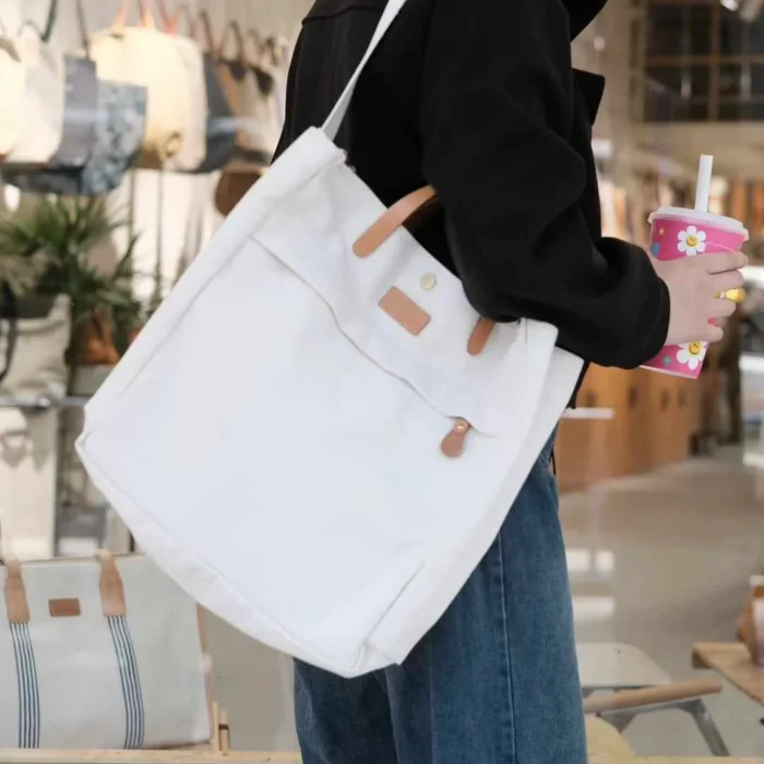 Close-up on model carrying the Canvas Tote Bag showing comfortable fit