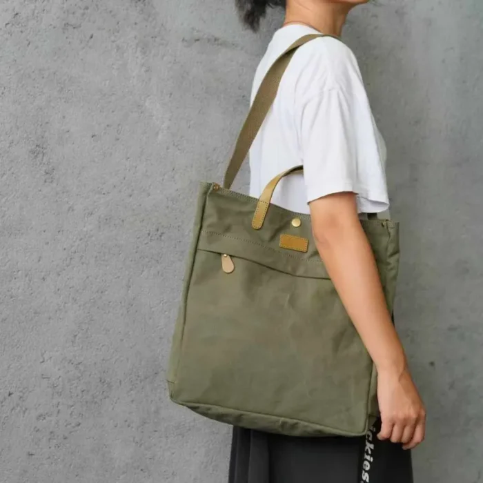 Model wearing the Canvas & Leather Tote Bag in a chic commuter setting