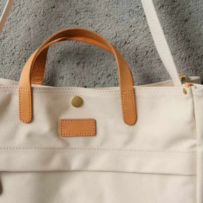 Close-up of genuine leather hand-carry straps on the tote