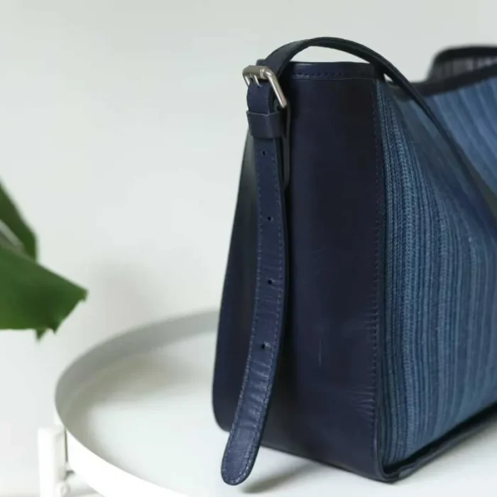 Side profile of the Striped Denim Leather Shoulder Bag, highlighting its practical depth and structure.