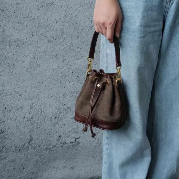 Close-up of the Coffee Brown Canvas Leather Mini Bucket Bag, highlighting its vintage crossbody bag features and rich leather patina.