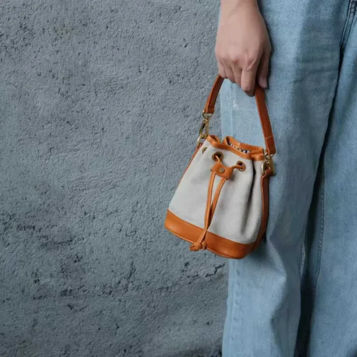Rice White Canvas Leather Mini Bucket Bag (front view), showing the clean canvas and light-toned oil waxed leather trim for a fresh summer look.