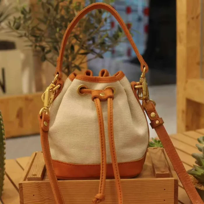 Canvas Leather Mini Bucket Bag in Coffee Brown, showcasing the stripe-woven canvas and oil waxed leather trim.
