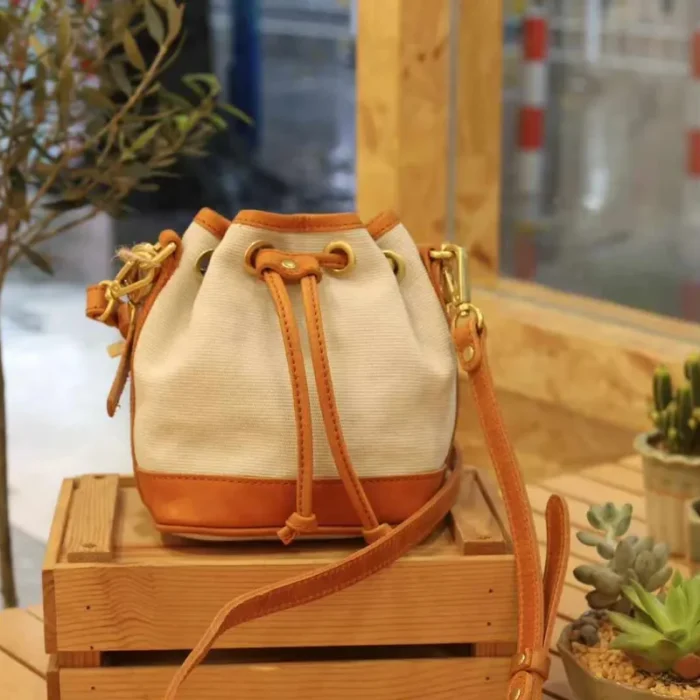 Canvas Leather Mini Bucket Bag in Coffee Brown, showcasing the stripe-woven canvas and oil waxed leather trim.