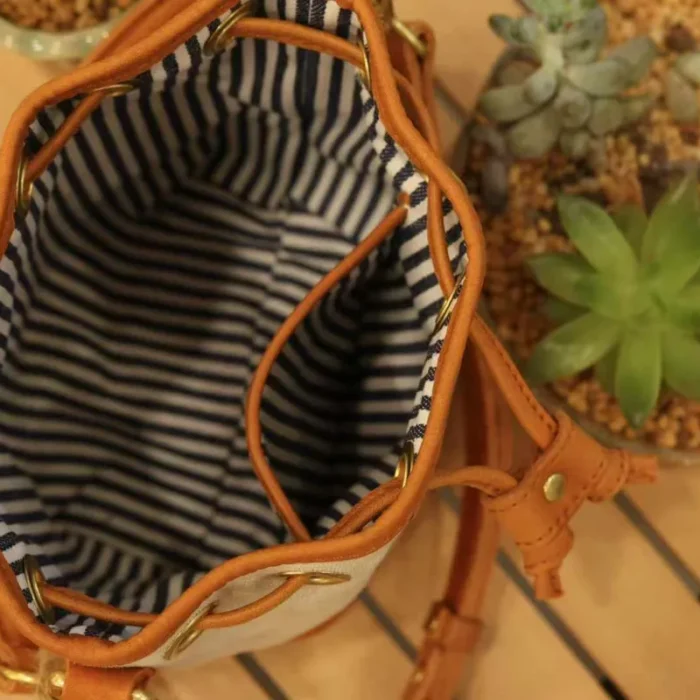 nterior view of the Canvas Leather Mini Bucket Bag, showing ample space for essentials like phone and wallet.