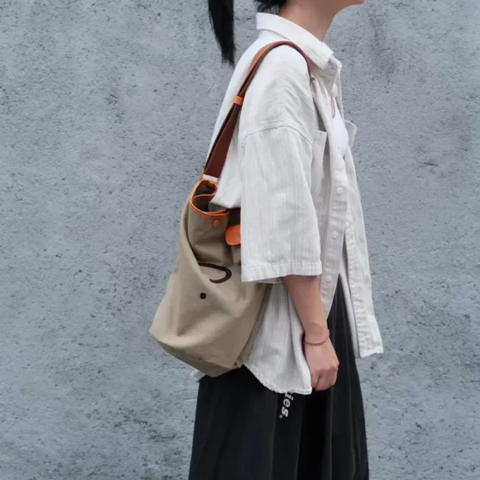 Man or Woman wearing the Navy Blue Bucket Bag on the shoulder, showing the relaxed fit and large capacity.