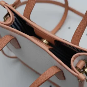 Detail of the secure magnetic snap button closure on the Canvas Mini Tote opening.