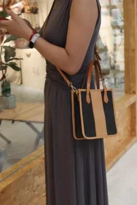 Model wearing the Canvas Mini Tote hands-free as a crossbody bag, perfect for travel or shopping.