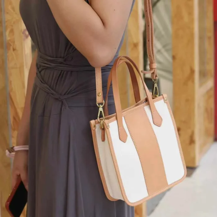 Model wearing the Vegetable Tanned Leather Canvas Mini Tote as a comfortable shoulder bag for daily errands.