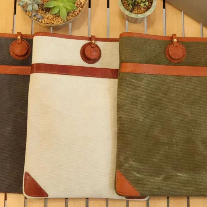 Full color range of Lightweight Leather Canvas Sleeve (Ivory White, Olive Green, Deep Grey) stacked together.