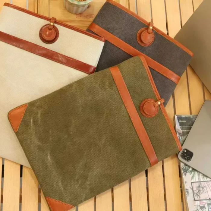 Full color range of Lightweight Leather Canvas Sleeve (Ivory White, Olive Green, Deep Grey) stacked together.
