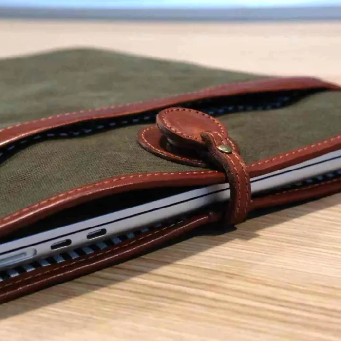Lightweight Leather Canvas Sleeve in Deep Grey (16-inch size) with a MacBook Pro half-inserted, emphasizing the snug fit.