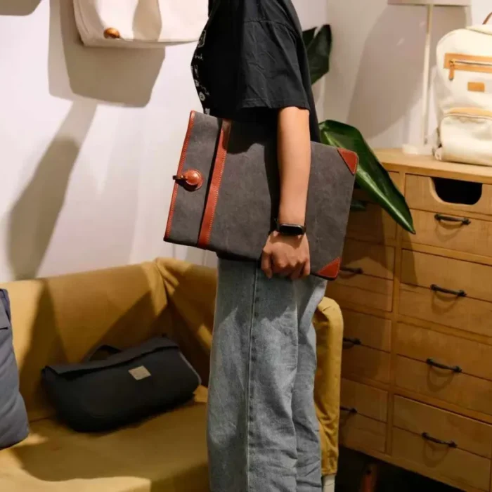 Lightweight Leather Canvas Sleeve in Deep Grey (16-inch size) with a MacBook Pro half-inserted, emphasizing the snug fit.