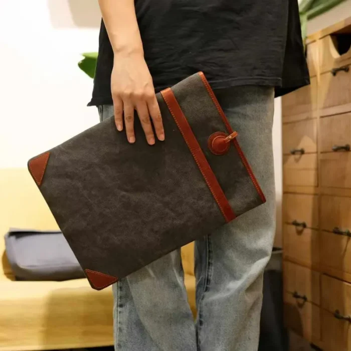 Lightweight Leather Canvas Sleeve in Deep Grey (16-inch size) with a MacBook Pro half-inserted, emphasizing the snug fit.