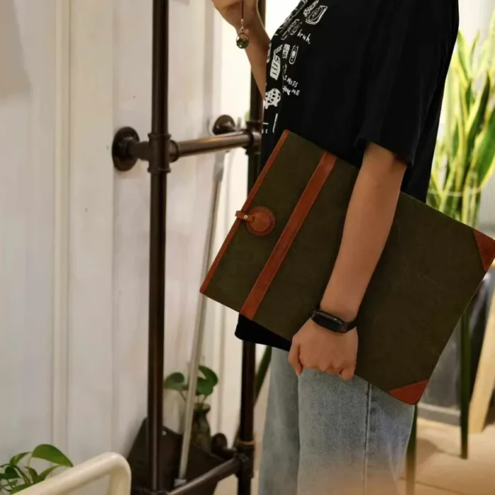 Lightweight Leather Canvas Sleeve in Deep Grey (16-inch size) with a MacBook Pro half-inserted, emphasizing the snug fit.