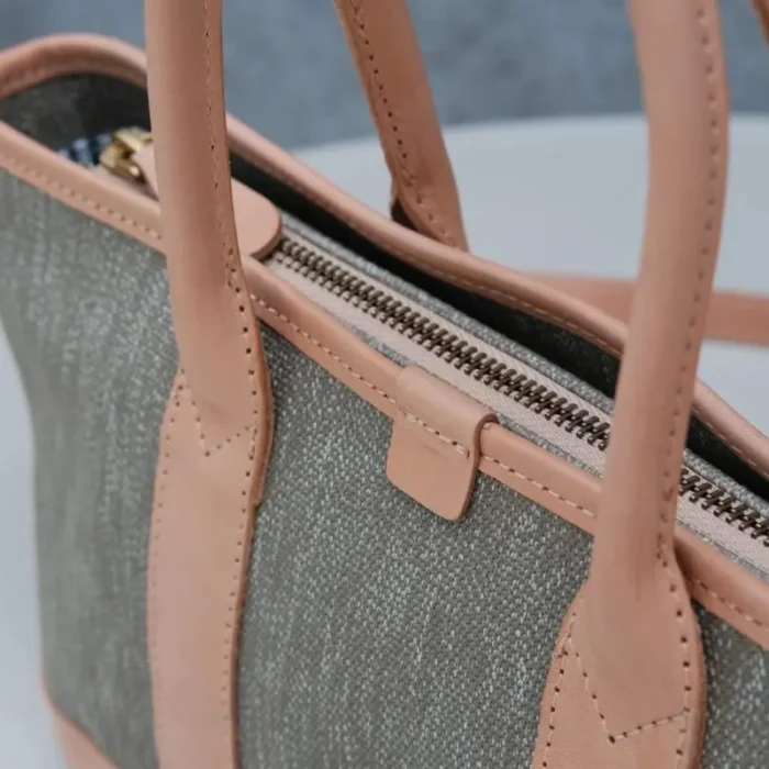Close-up of the durable YKK brass zipper pull on the SYMONHO canvas tote, highlighting the quality hardware.